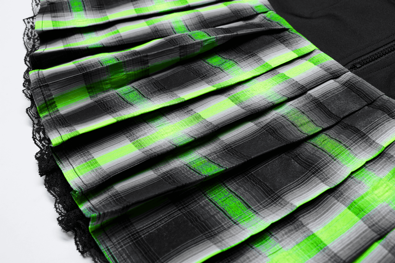 Close-up of punk female plaid skirt with lace trim, featuring bold green and black pleats.