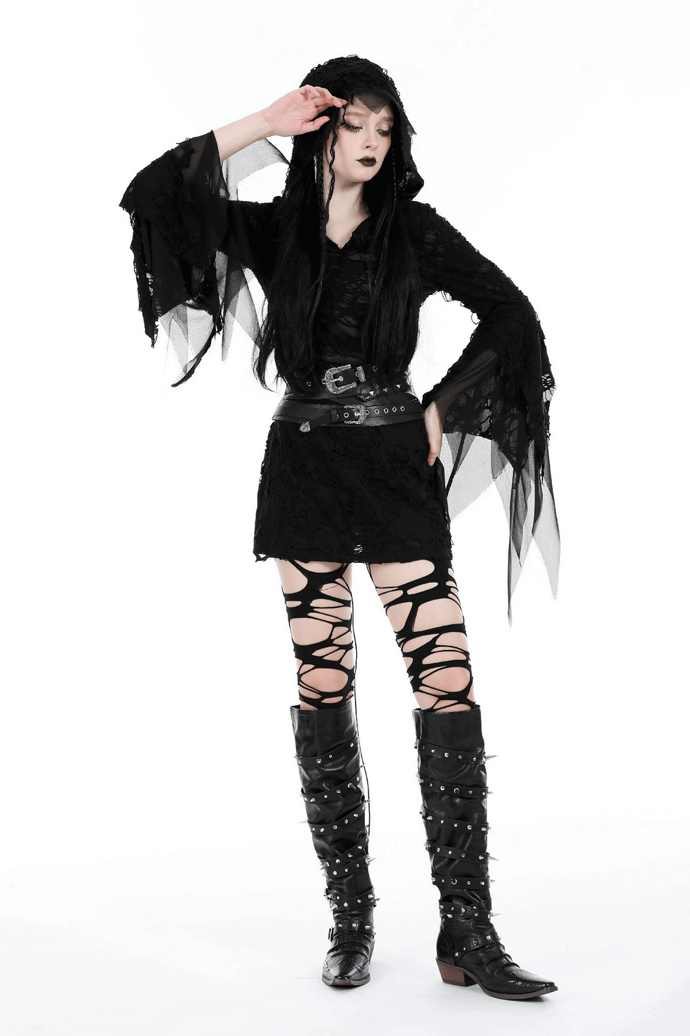 Punk style female model in black corset belt, lace dress, knee-high boots with silver accents, showcasing edgy fashion.