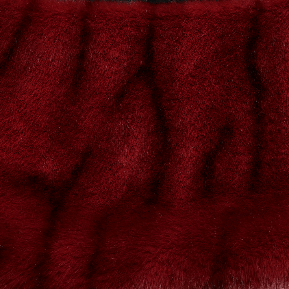Close-up of plush red faux fur fabric for a punk-style skirt, showcasing its soft texture and vibrant color.