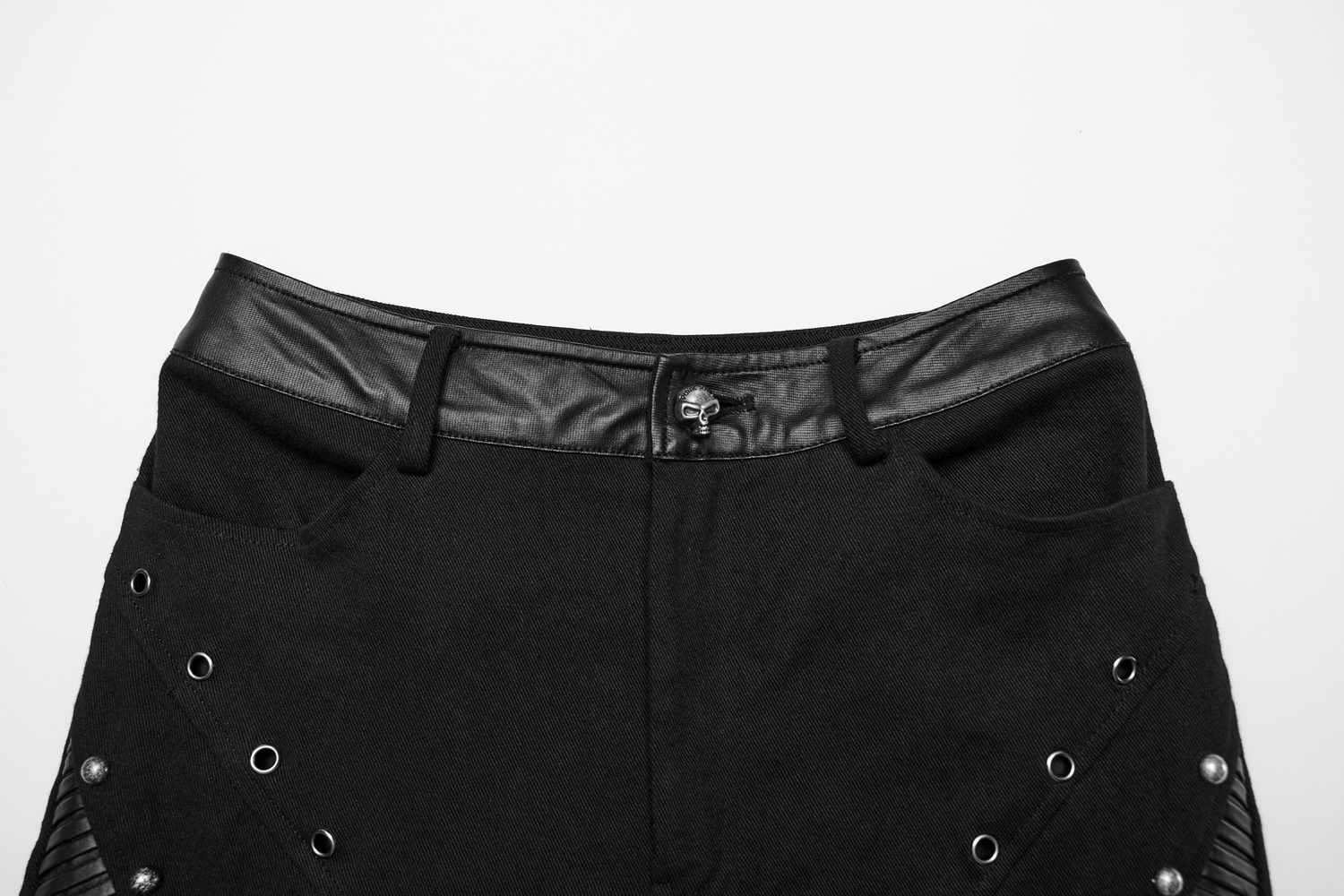 Close-up of punk flare trousers with leather panels and rivets, showcasing edgy design and unique details.