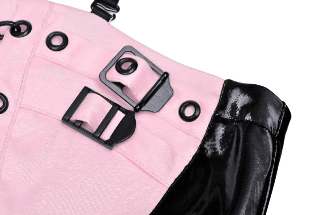Close-up of punk glossy vinyl mini dress showing pink fabric, black patent leather, and stylish buckles.
