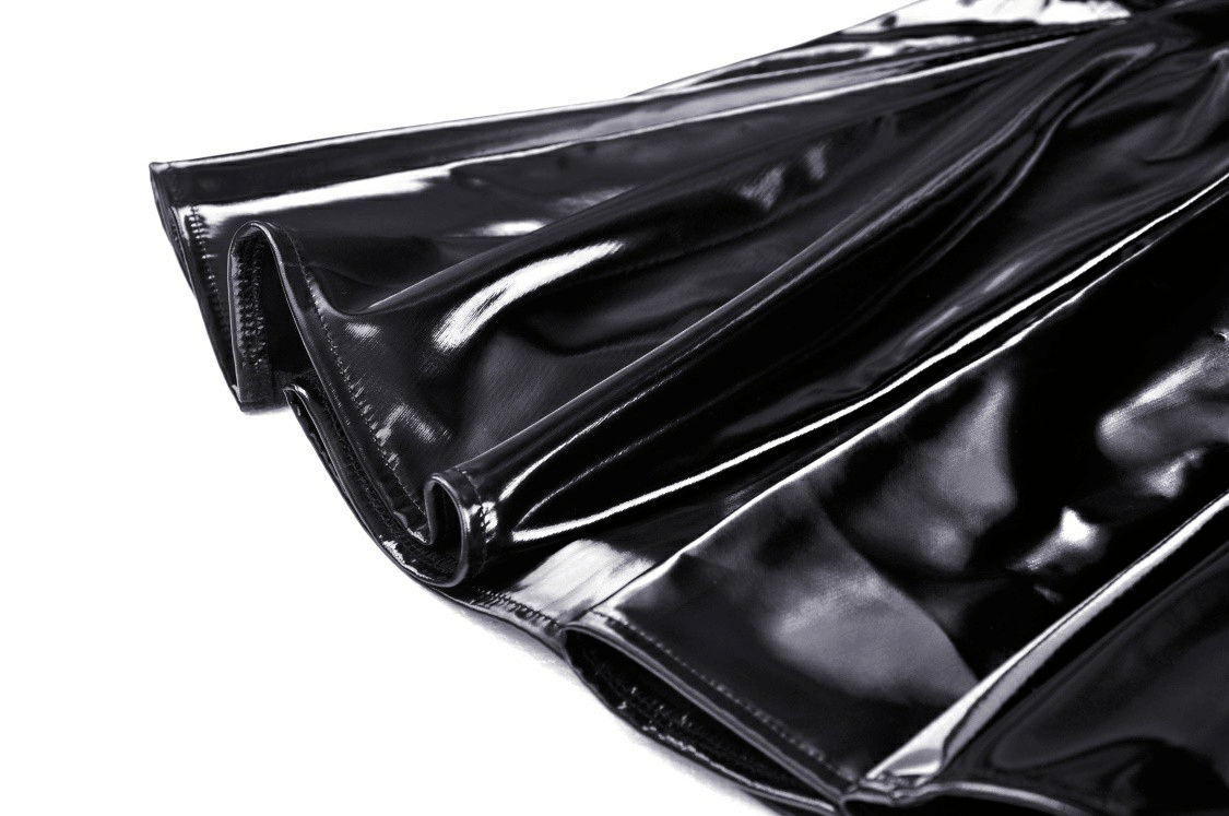 Close-up of black glossy vinyl fabric folds highlighting the shine and texture of a punk-inspired mini dress.