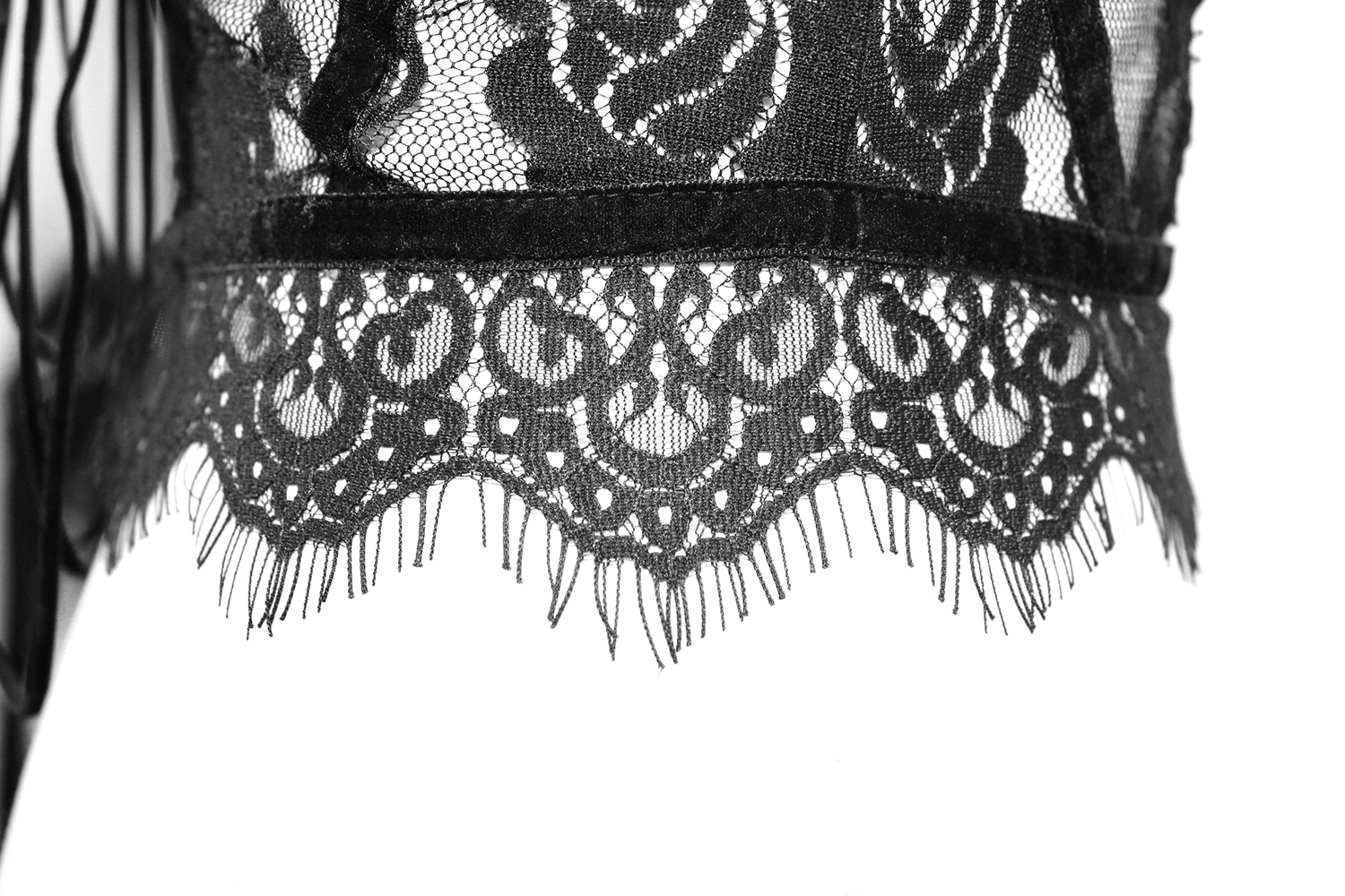 Close-up of intricate lace detailing on a black transparent corset for a gothic style outfit.