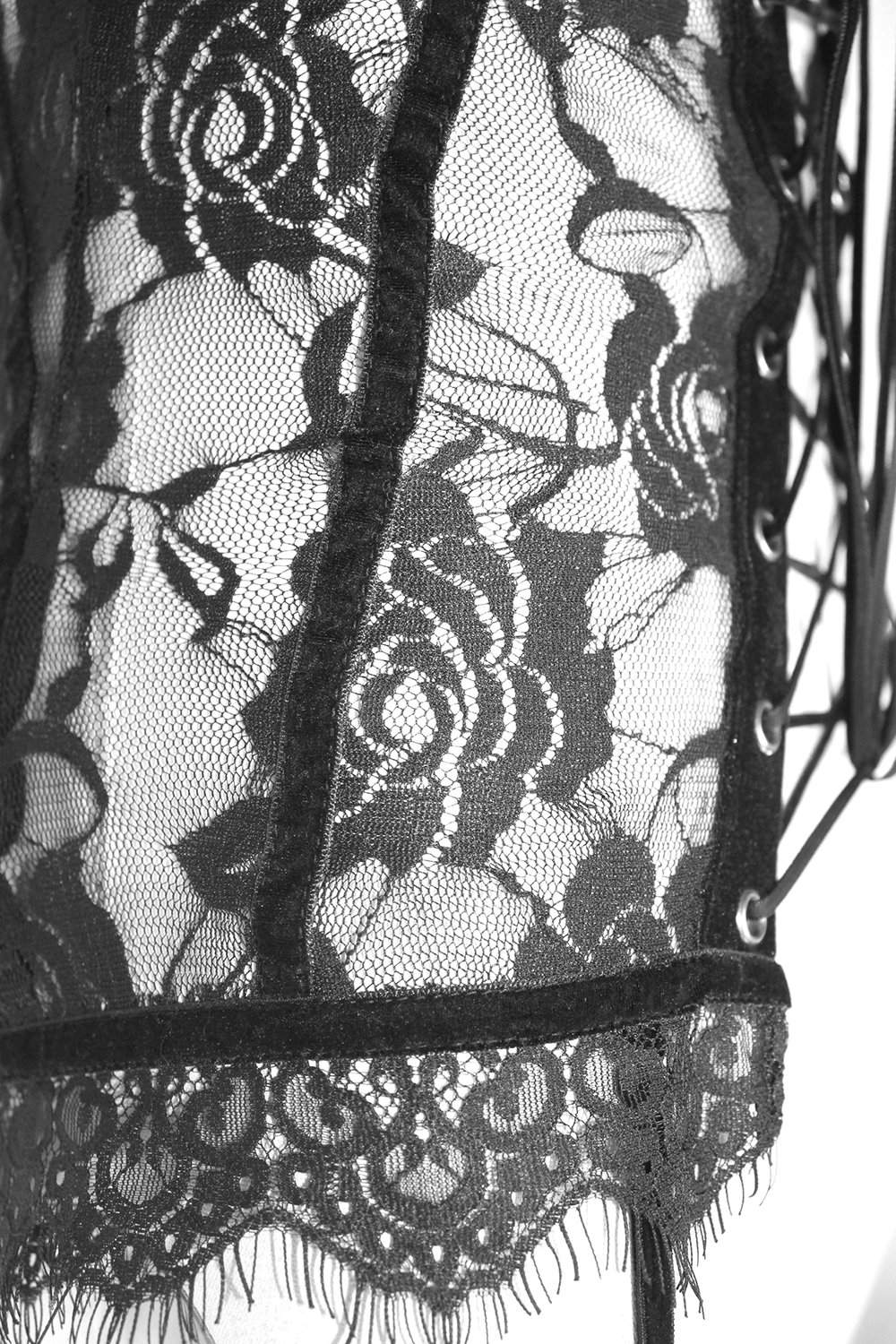Close-up of black lace fabric with floral pattern, highlighting the intricate design of a punk-gothic corset top.