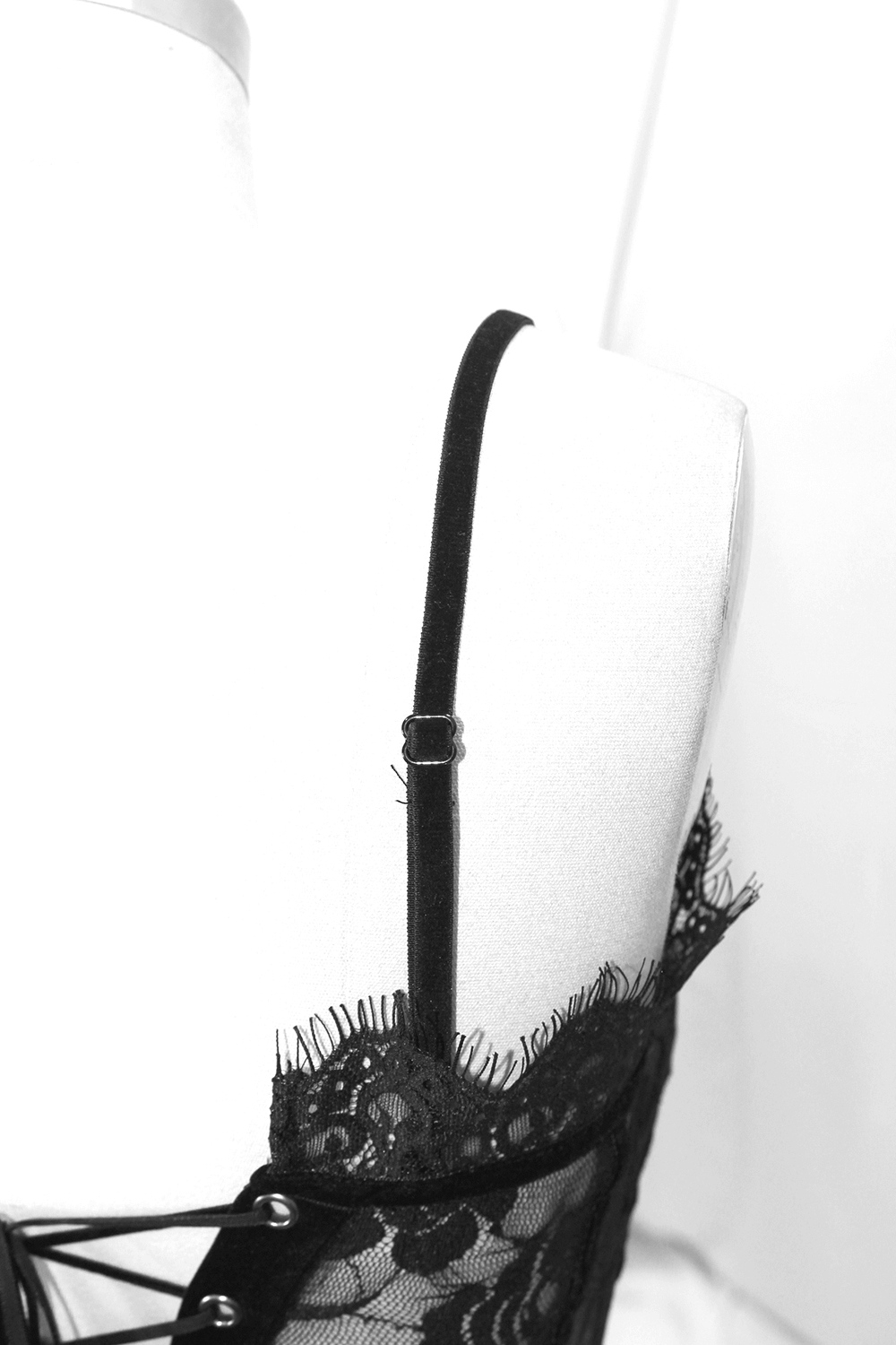 Close-up of a black lace crop top strap showcasing gothic styling and intricate lace details.