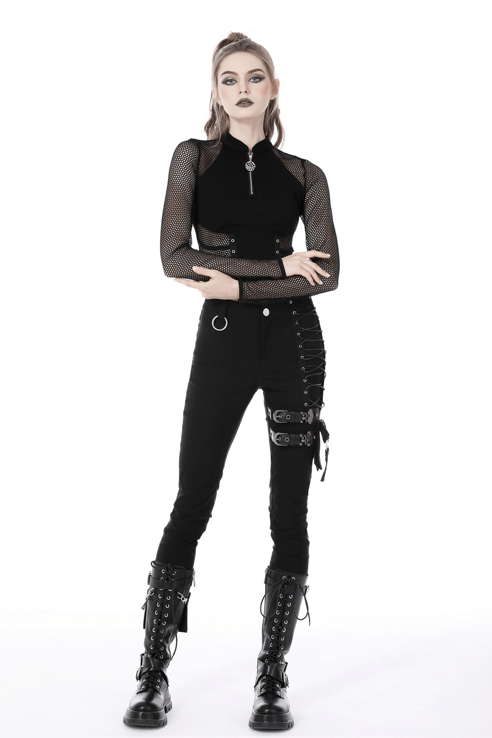 Edgy model in punk gothic zip-up mesh crop top and black pants, showcasing a fierce fashion statement.