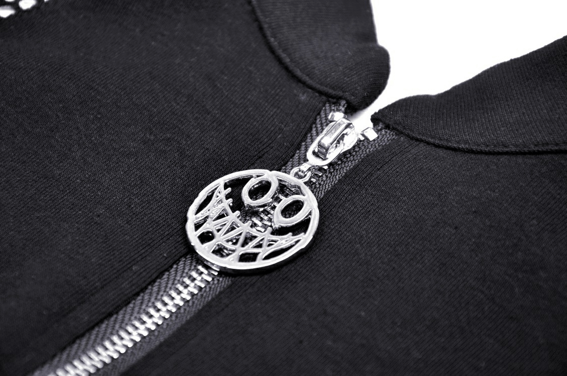Close-up of a silver zipper pull on a black gothic crop top, showcasing edgy punk style and intricate detailing.