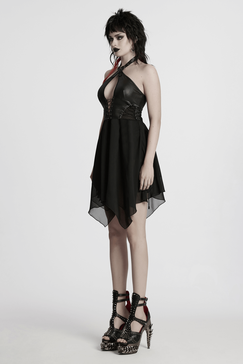 Punk halter neck dress with lace-up detailing and chiffon hem, paired with stylish studded heels in a fashion shoot.