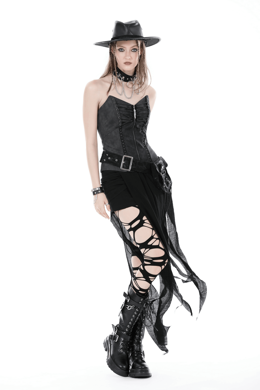 Gothic model in black corset, asymmetrical skirt, and boots, exuding punk rock style with lace and edgy accessories.