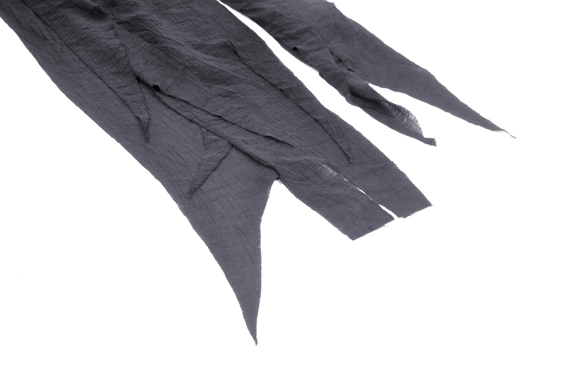 Close-up of black gothic asymmetrical fabric with jagged edges for dramatic punk fashion styles.