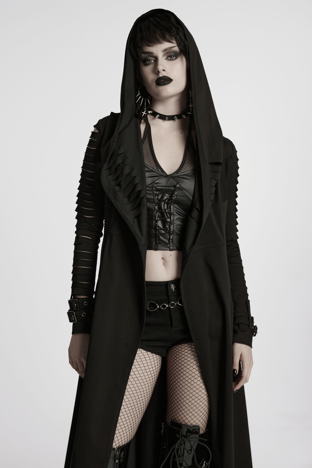 Punk hooded cape with side pockets, stylishly combined with a black outfit and bold accessories.