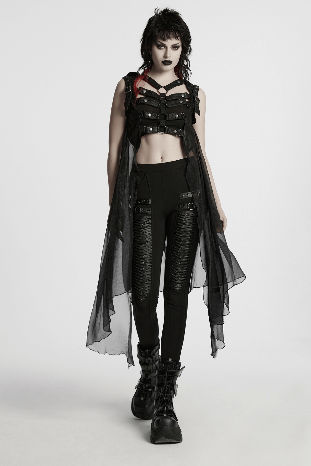 Edgy model showcasing a punk hooded skeleton cape with metal rings, paired with sleek black leggings and boots.