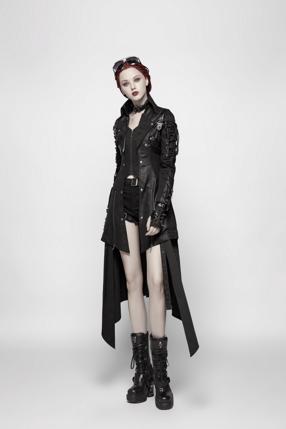 Punk-inspired black rubberized coat with laces, worn by a model showcasing edgy style and bold fashion.