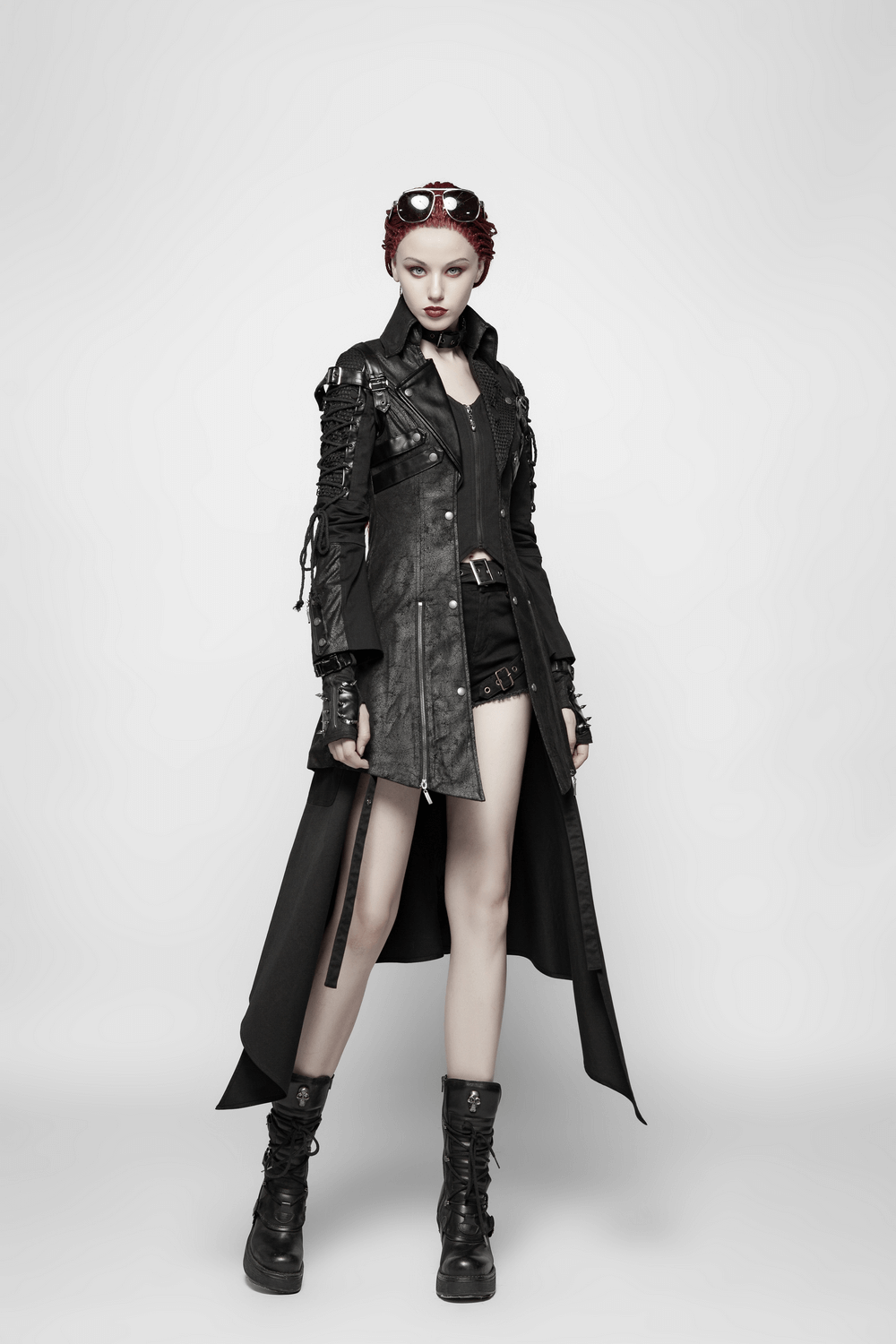 Bold punk-inspired model in a black rubberized coat with lace details and combat boots.