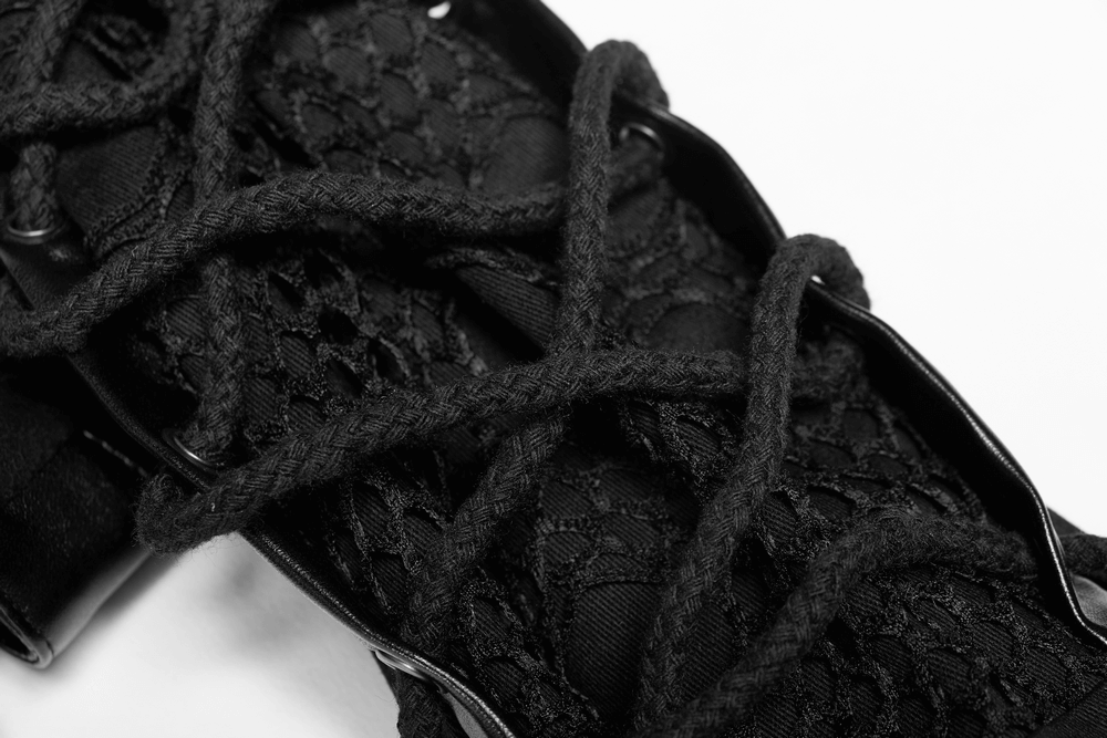 Close-up of intricate black lace detailing and laces on a punk-inspired rubber coat.