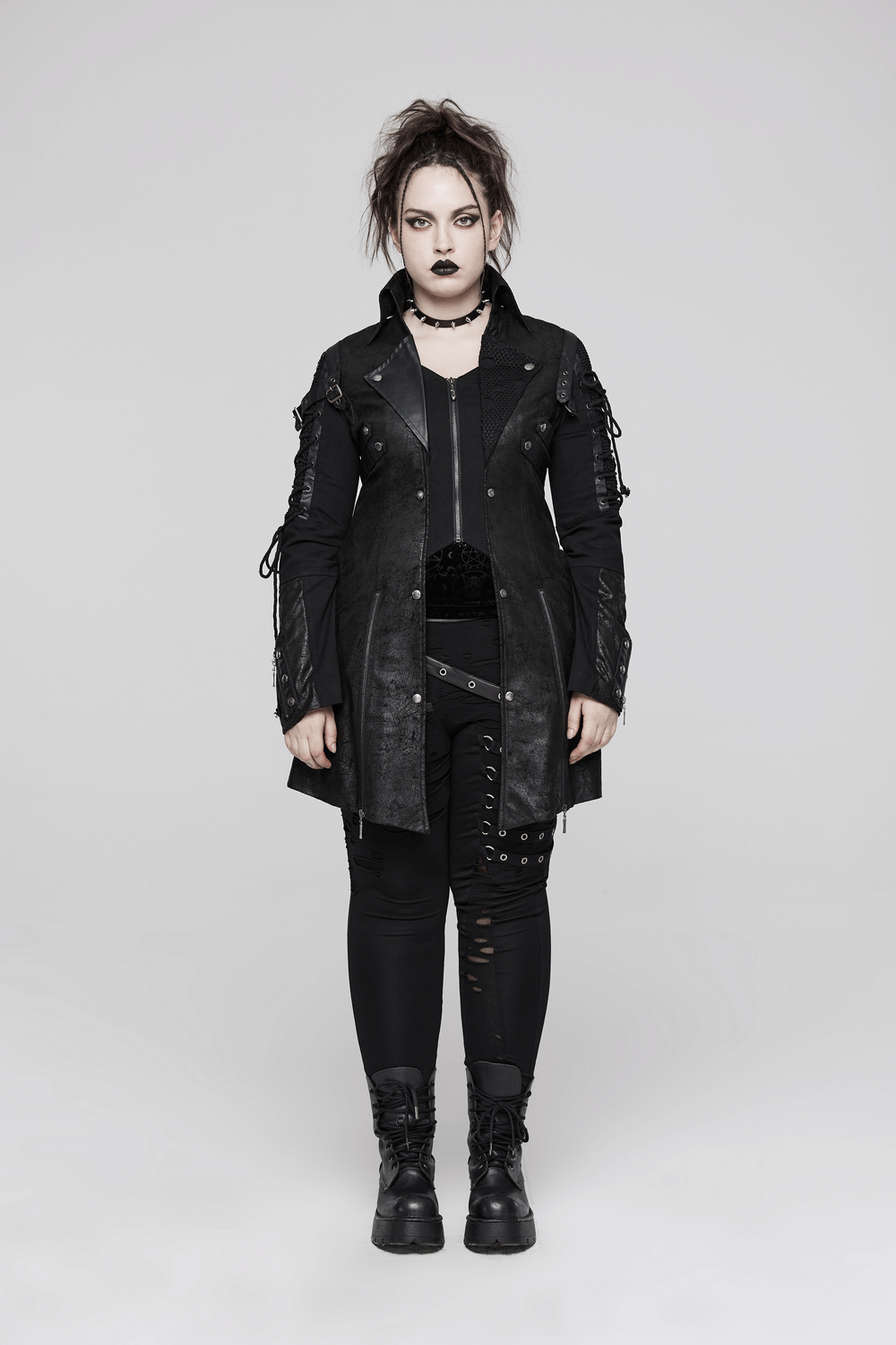 Punk-inspired black rubber long-sleeve coat with lace detailing and adjustable straps on edgy model.