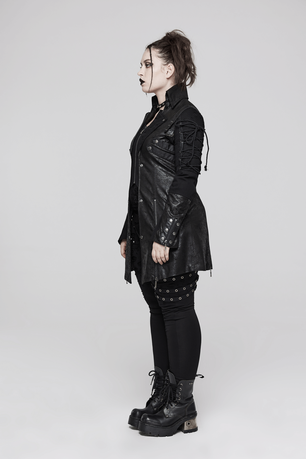 Punk-inspired black rubberized coat with laces, paired with edgy black platform boots for a bold look.