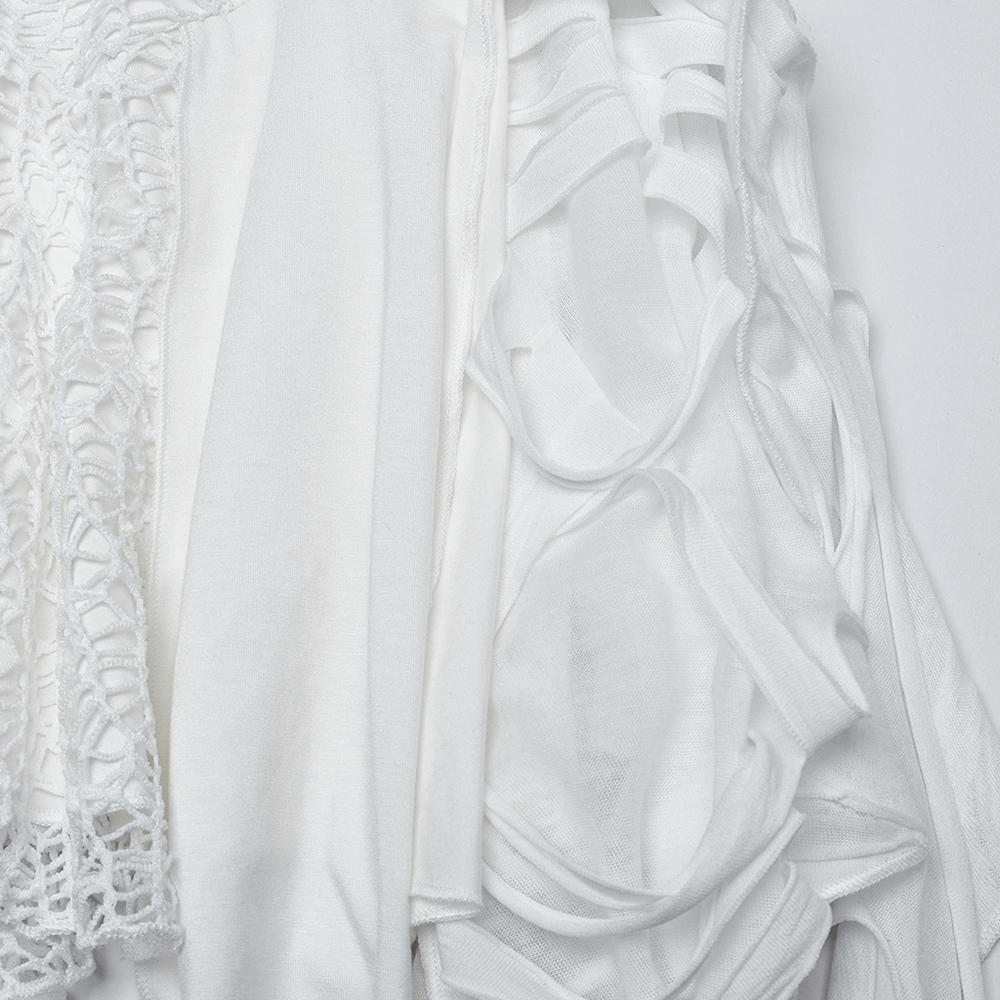 Close-up of textured white fabrics showcasing elegant and avant-garde design details for a punk-inspired dress.