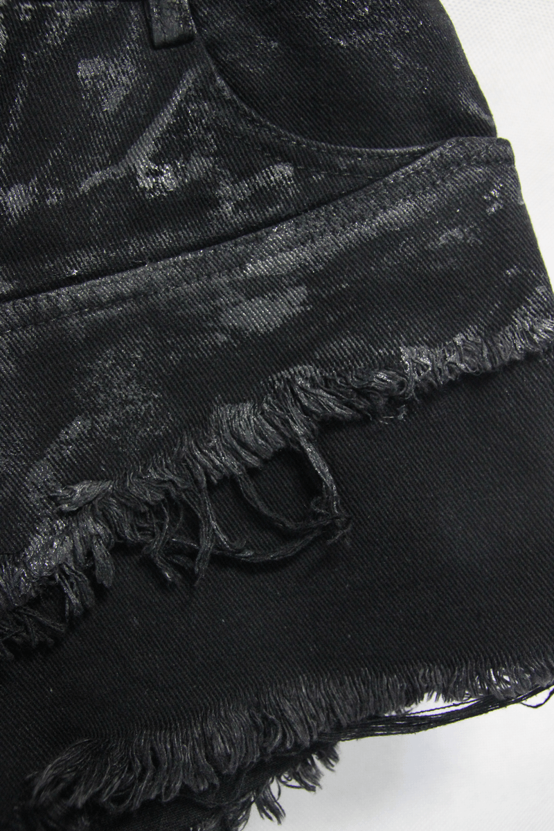 Close-up of women's black ripped punk shorts featuring distressed hem and stylish torn design.