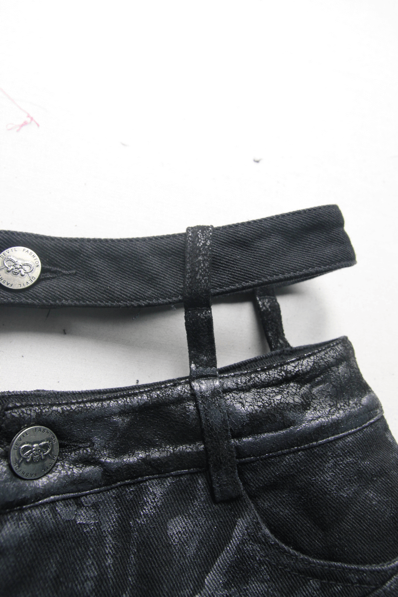 Close-up of punk ladies black ripped shorts featuring stylish waistband and metallic buttons, perfect for a gothic look.