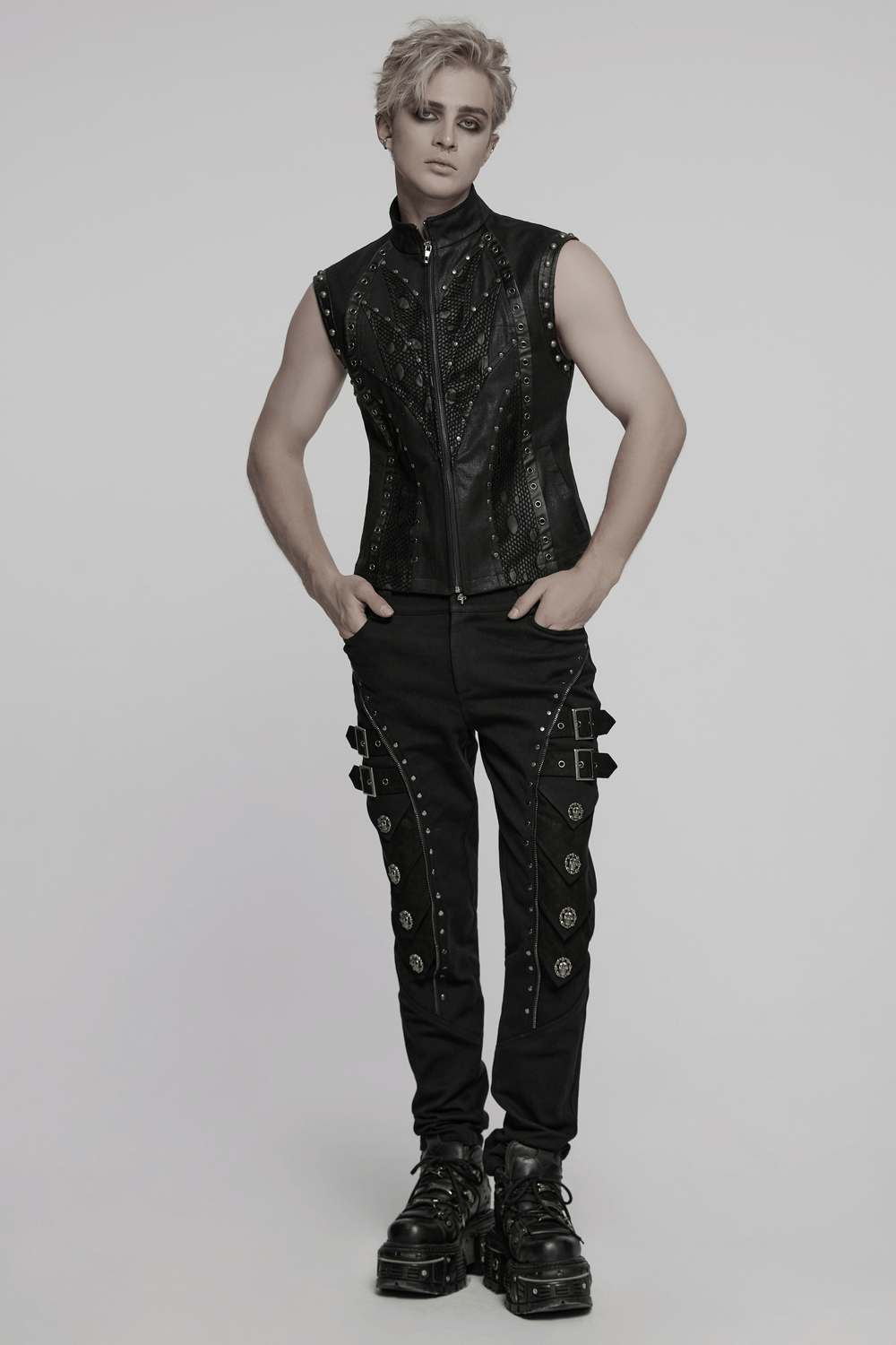 Handsome model in punk leather vest with rivets, showcasing a bold, edgy style with black pants and chunky boots.