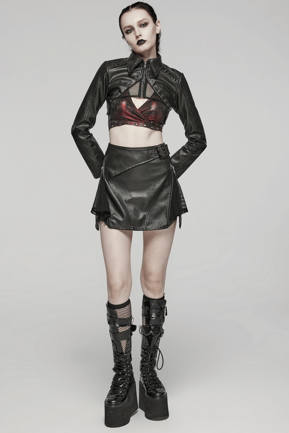 Edgy black faux leather mini skirt with mesh panels and side buckle, paired with a matching cropped jacket for a punk look.