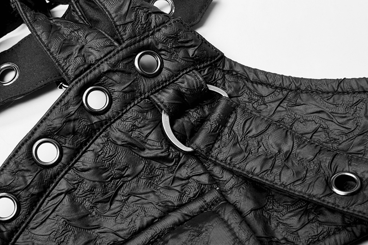 Gothic punk leather shoulder harness with metal accents and embossed texture featuring eyelets and buttons.
