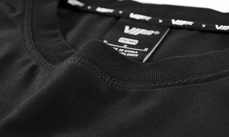 Close-up of a black punk loose solid T-shirt collar, showcasing the urban streetwear style and label.