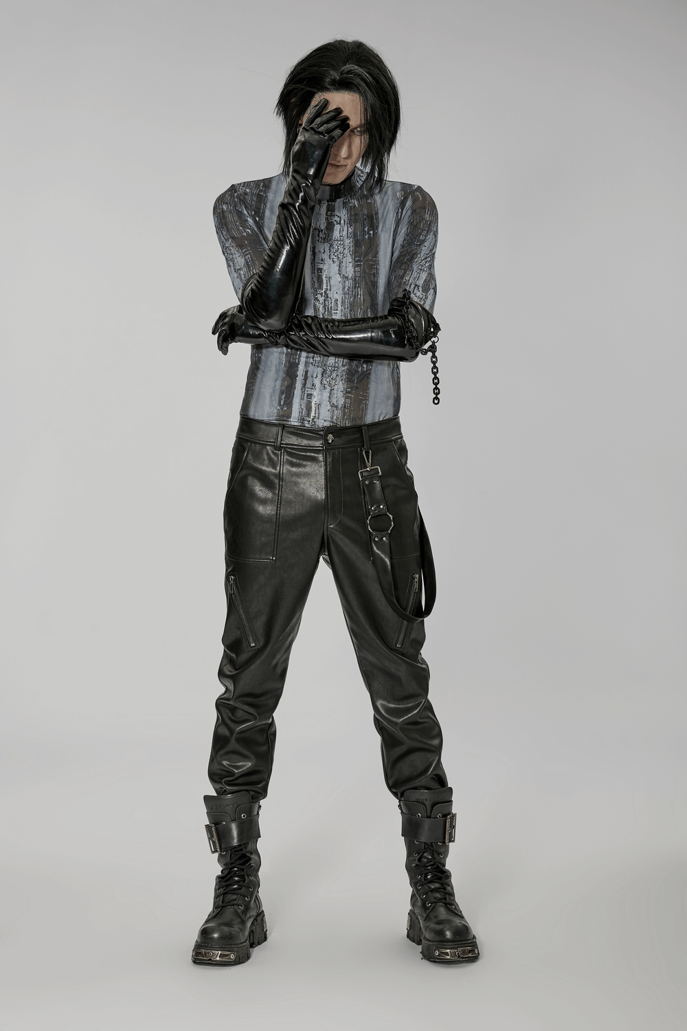 Edgy punk male styled in patent leather gloves with detachable chain, showcasing a sleek, rebellious look.