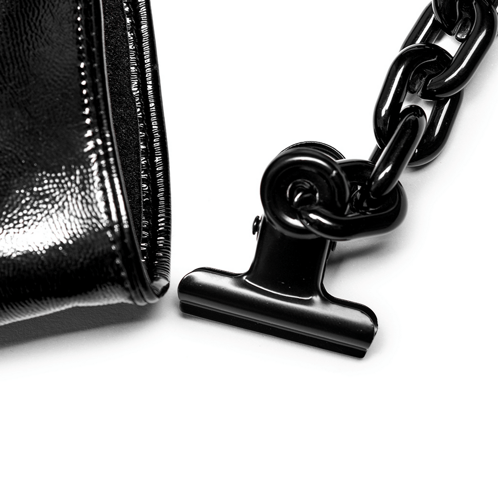 Close-up of glossy black patent leather gloves with a chunky detachable chain detail.