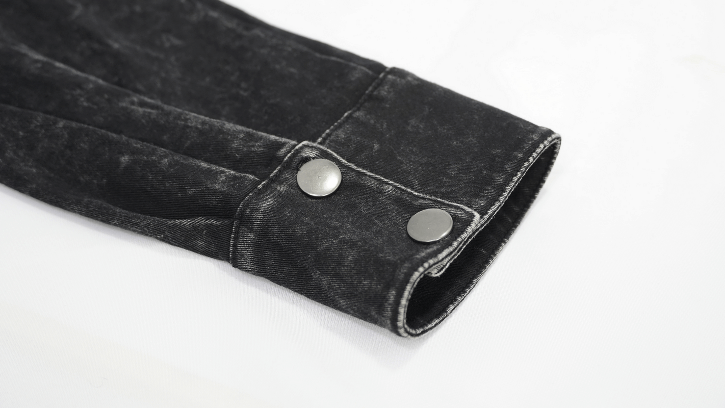Close-up of punk men's black shirt sleeve featuring PU leather flaps and stylish silver clasps.