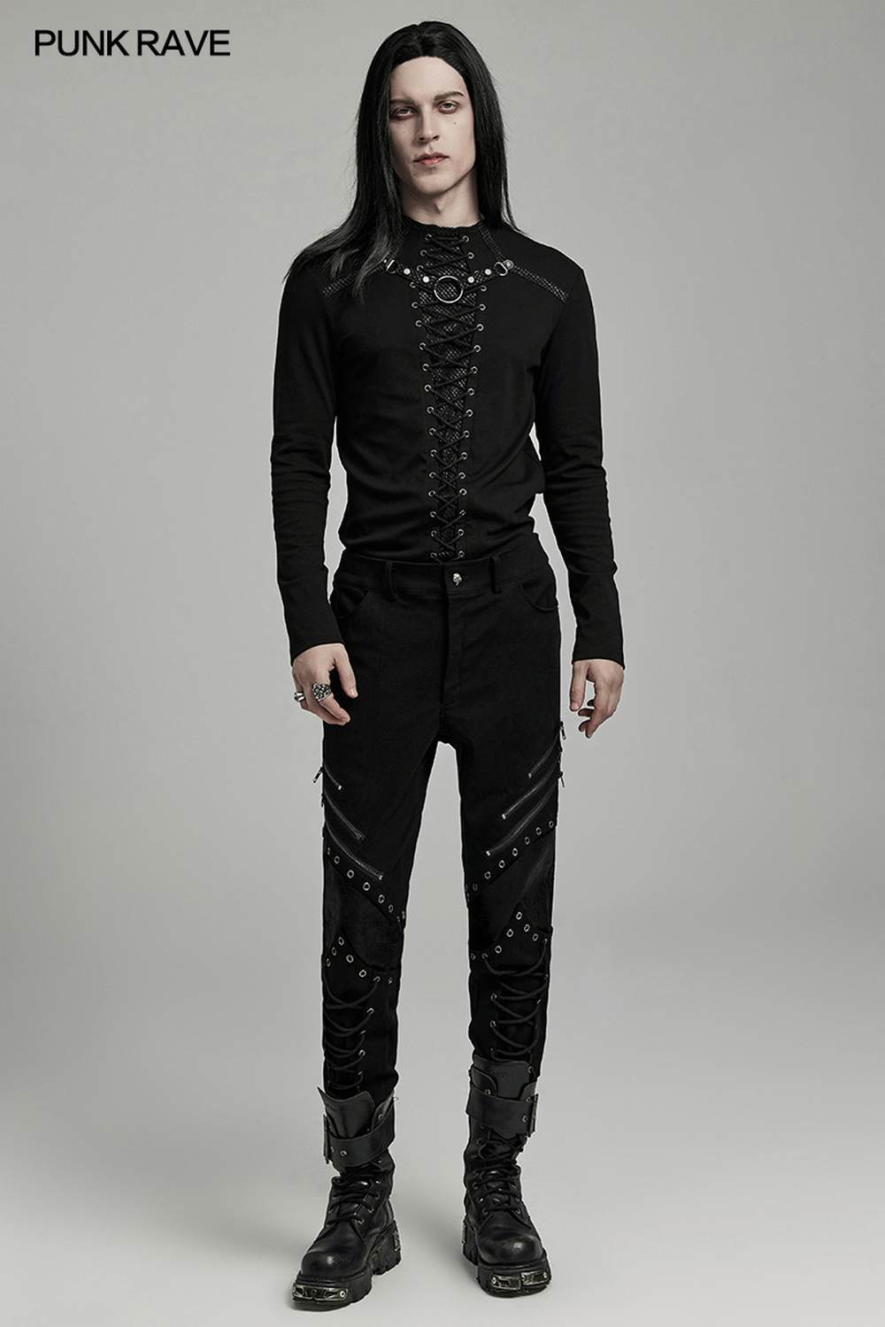 Punk men's black twill pants with zippers, eyelets, and gothic style, paired with a fitted black top.