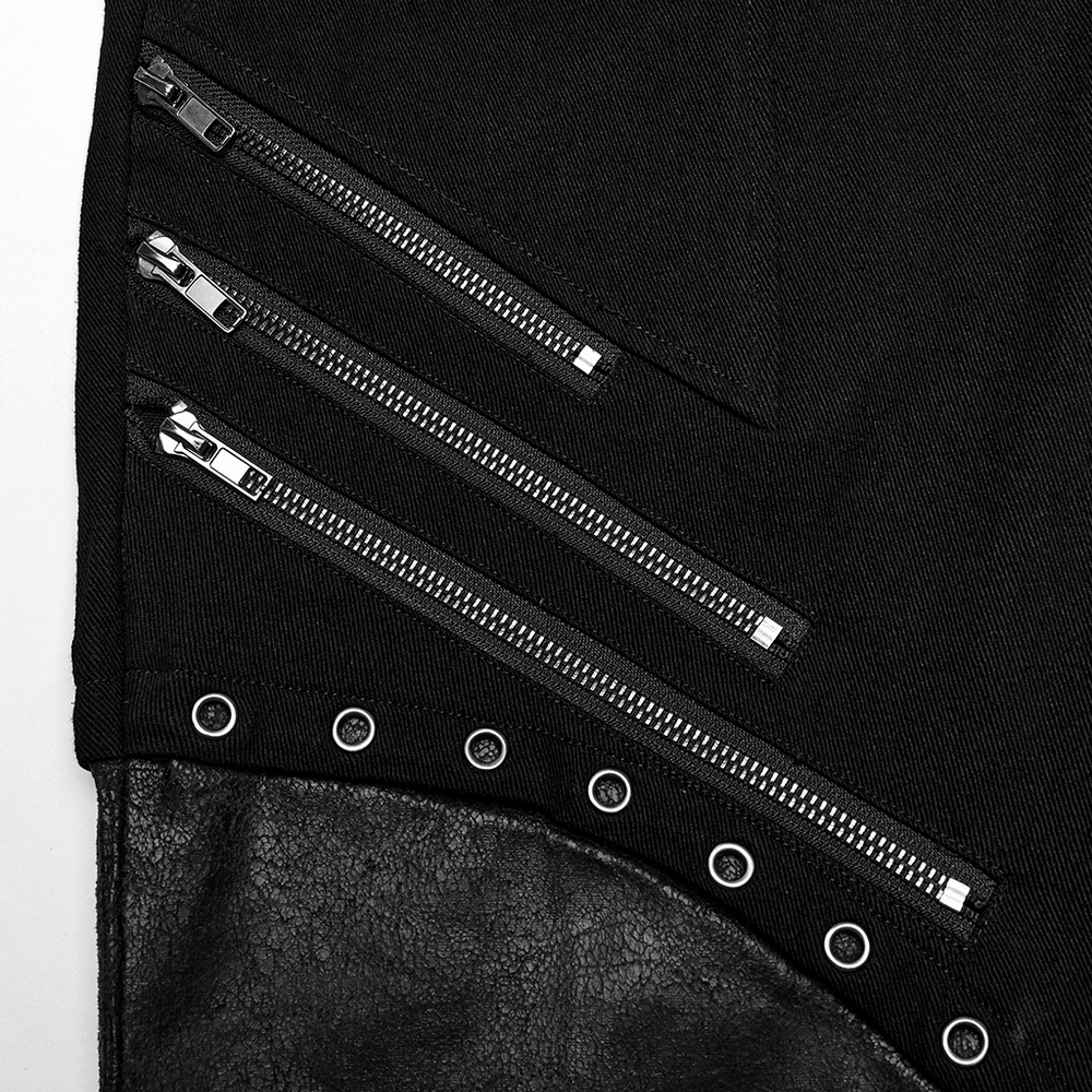 Close-up of black twill pants featuring zippers and metal eyelets in punk style.