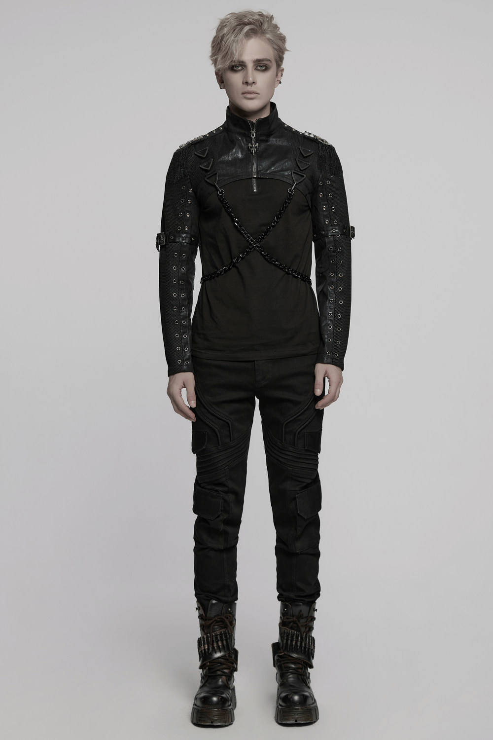 Model wearing a punk-inspired black outfit with chains, showcasing edgy alternative fashion style.