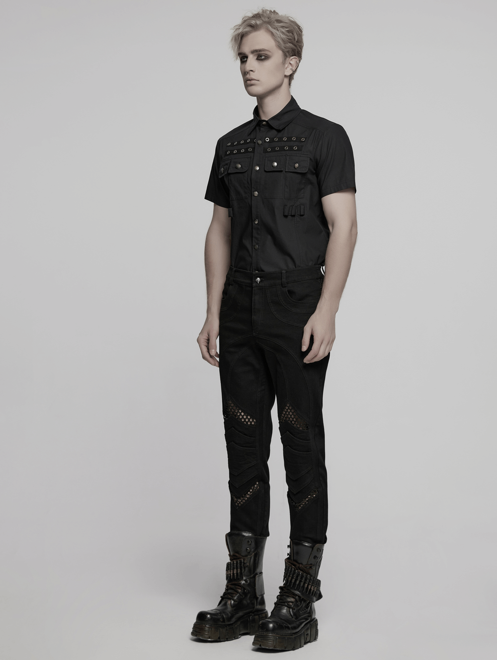 Stylish model wearing punk mesh detail tight pants with 3D knee pieces and a studded black shirt.