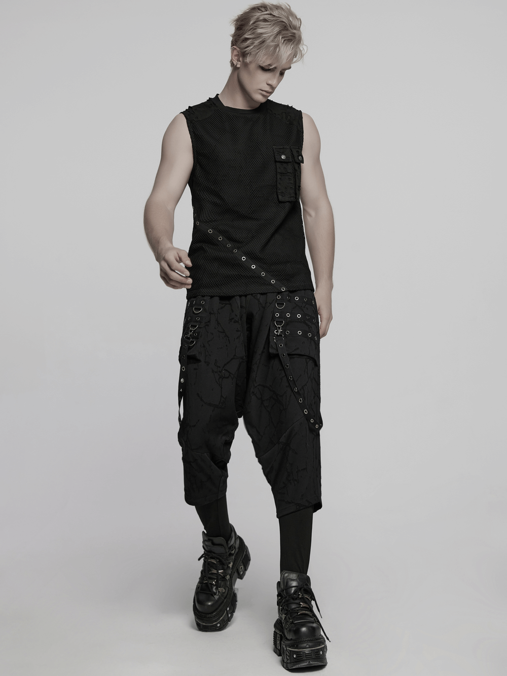 Stylish punk mesh top featuring tattered fabric and pocket details, paired with edgy black cargo pants.