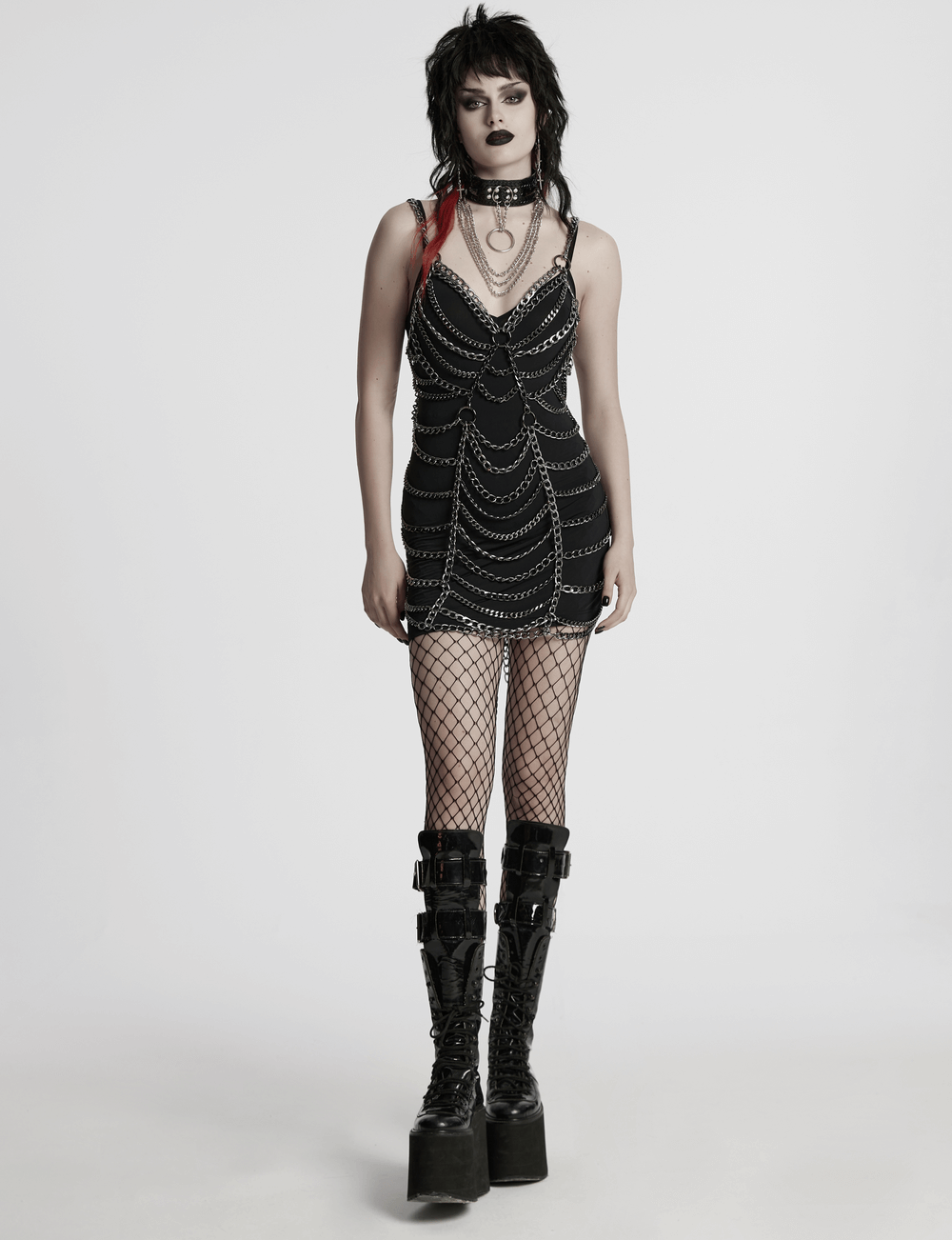 Punk metal chain body harness dress with adjustable chains, paired with fishnet stockings and platform boots.