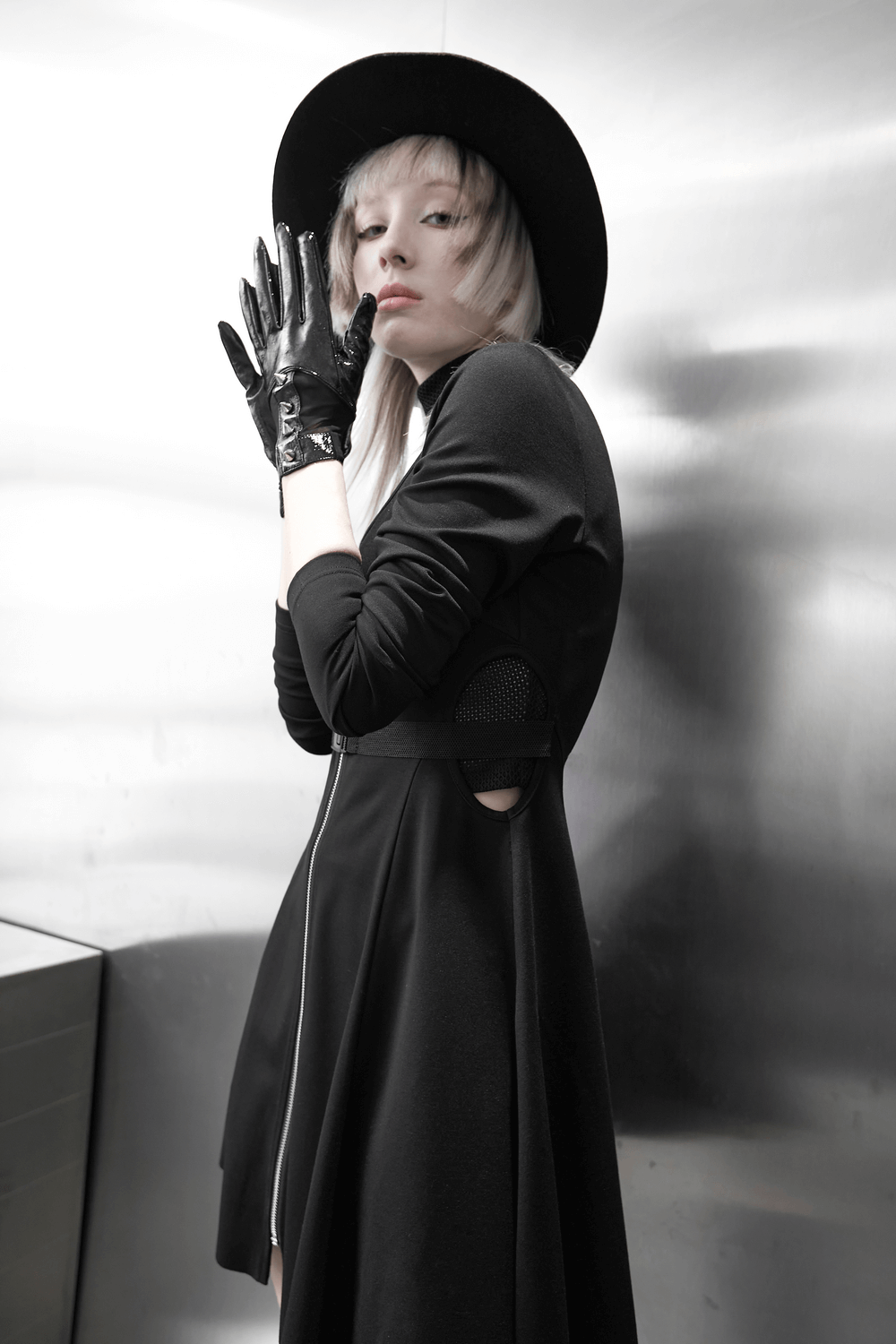 Chic model in black dress and punk metal rivet PU leather gloves exuding bold fashion and edgy style.