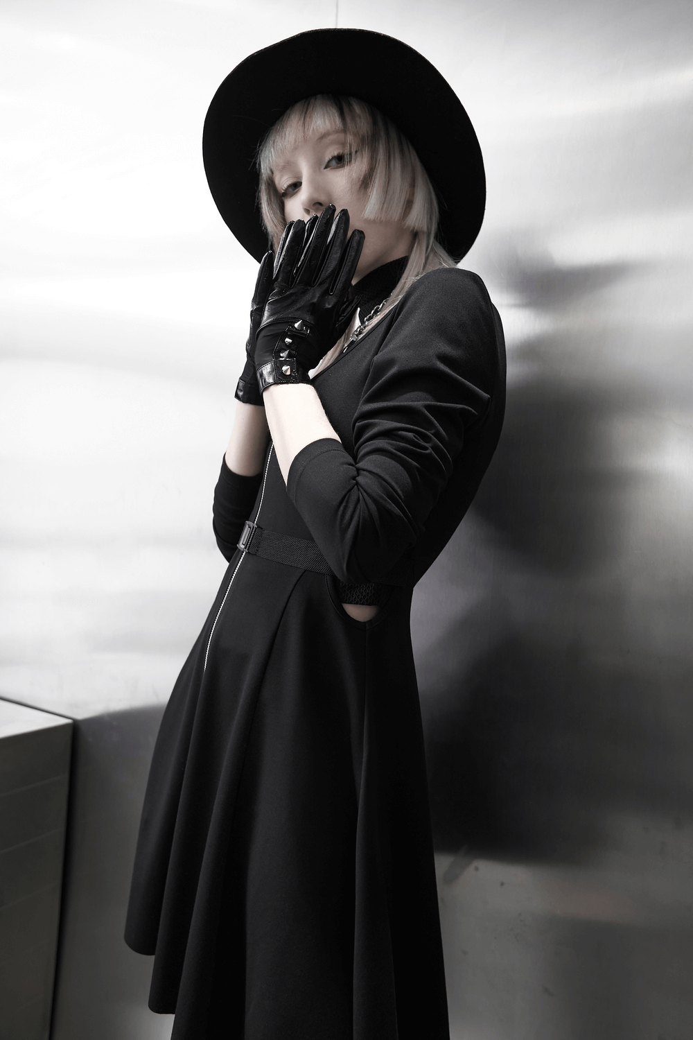 Model in black dress with punk metal rivet PU leather gloves and wide-brimmed hat, showcasing edgy fashion style.