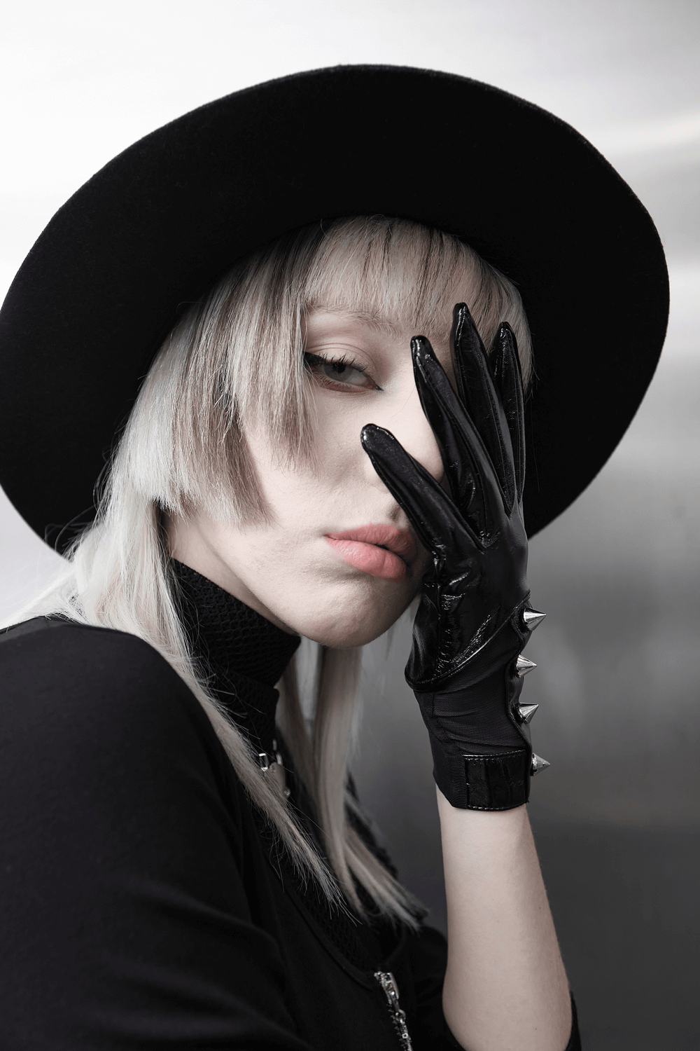 Punk metal rivet PU leather gloves worn by model with a black hat, showcasing edgy fashion and bold style.