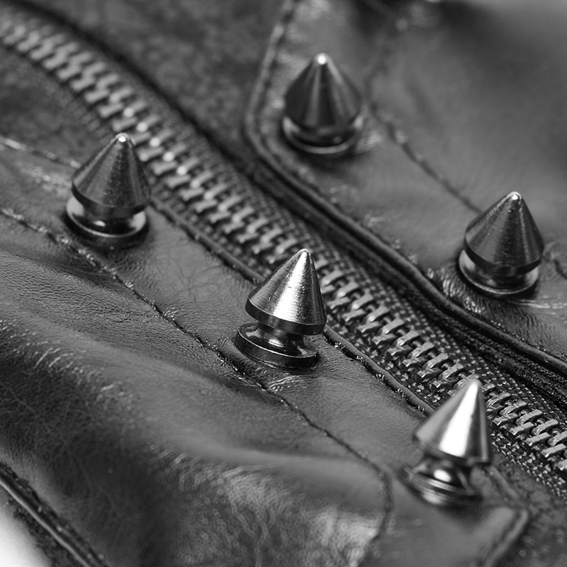 Close-up of black leather with silver spikes and zipper, showcasing edgy punk fashion details.