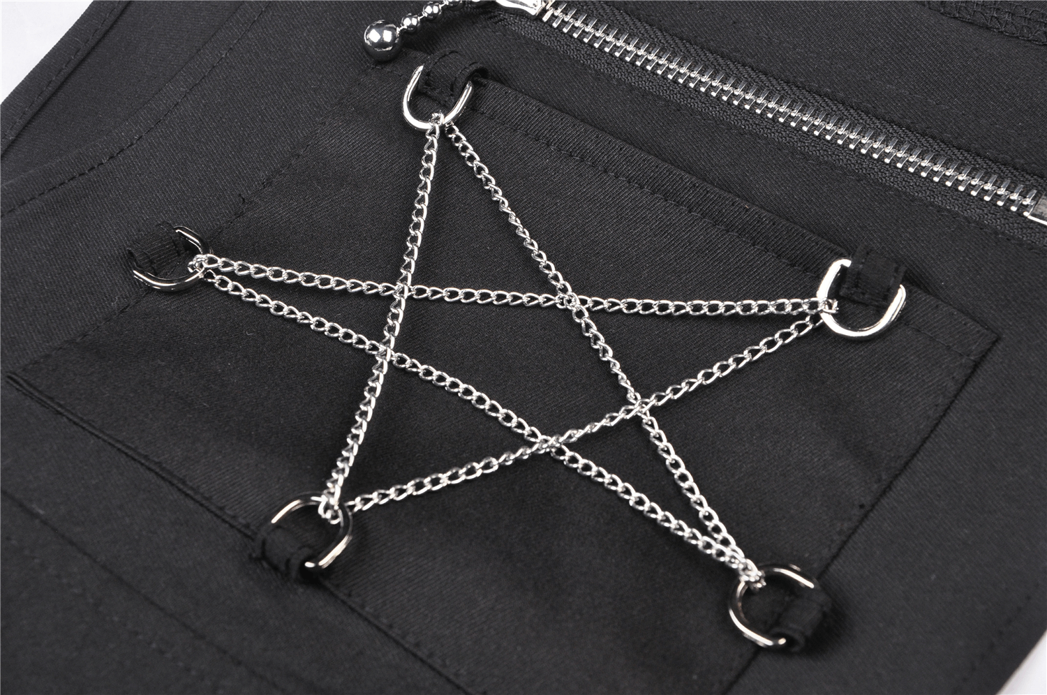 Close-up of a pentagram design with chains and rings on a black fabric, perfect for punk fashion enthusiasts.