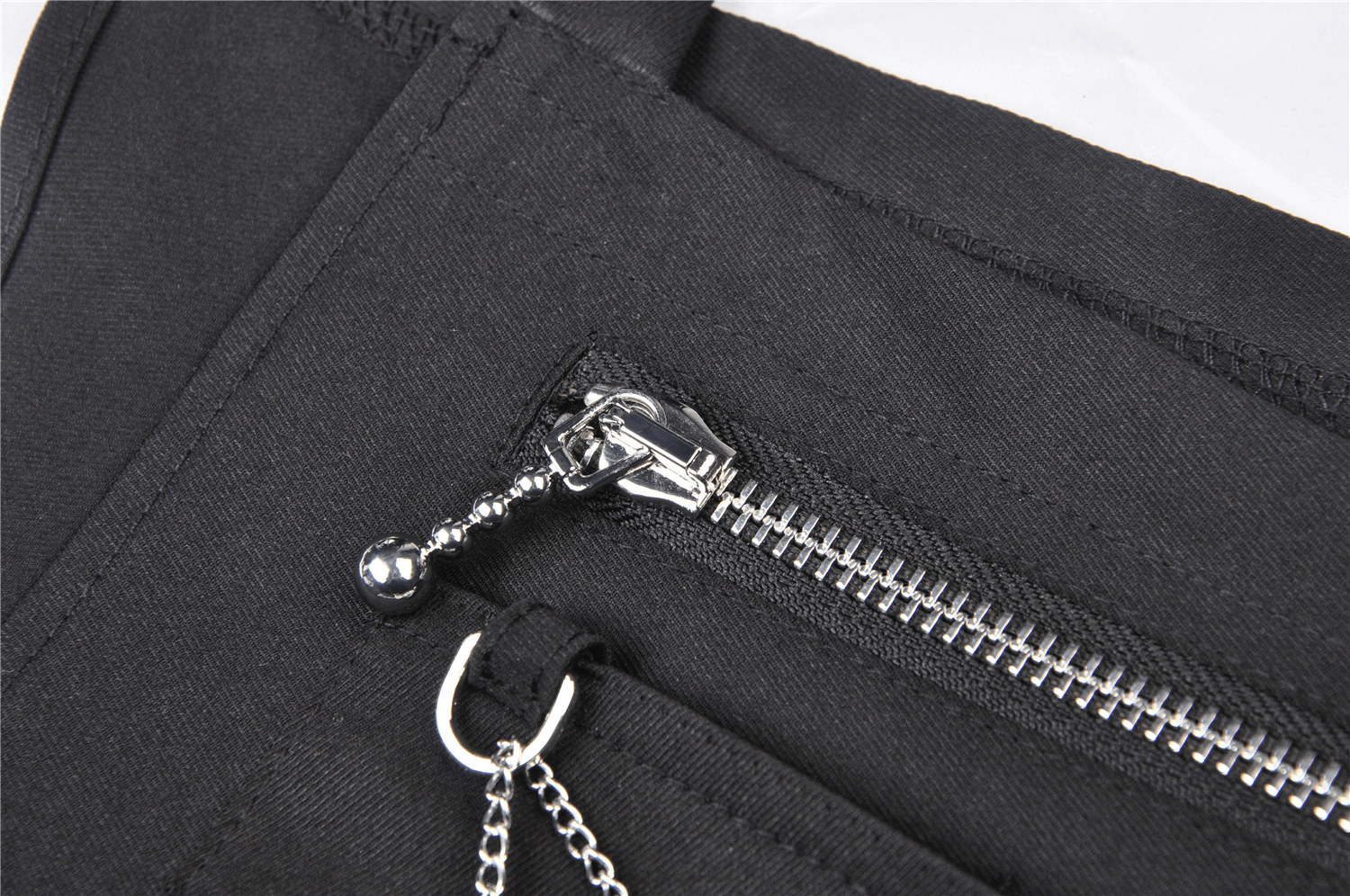Close-up of the zipper detail on a black Punk Pentagram Suspender Dress showcasing stylish stitching and silver chains.