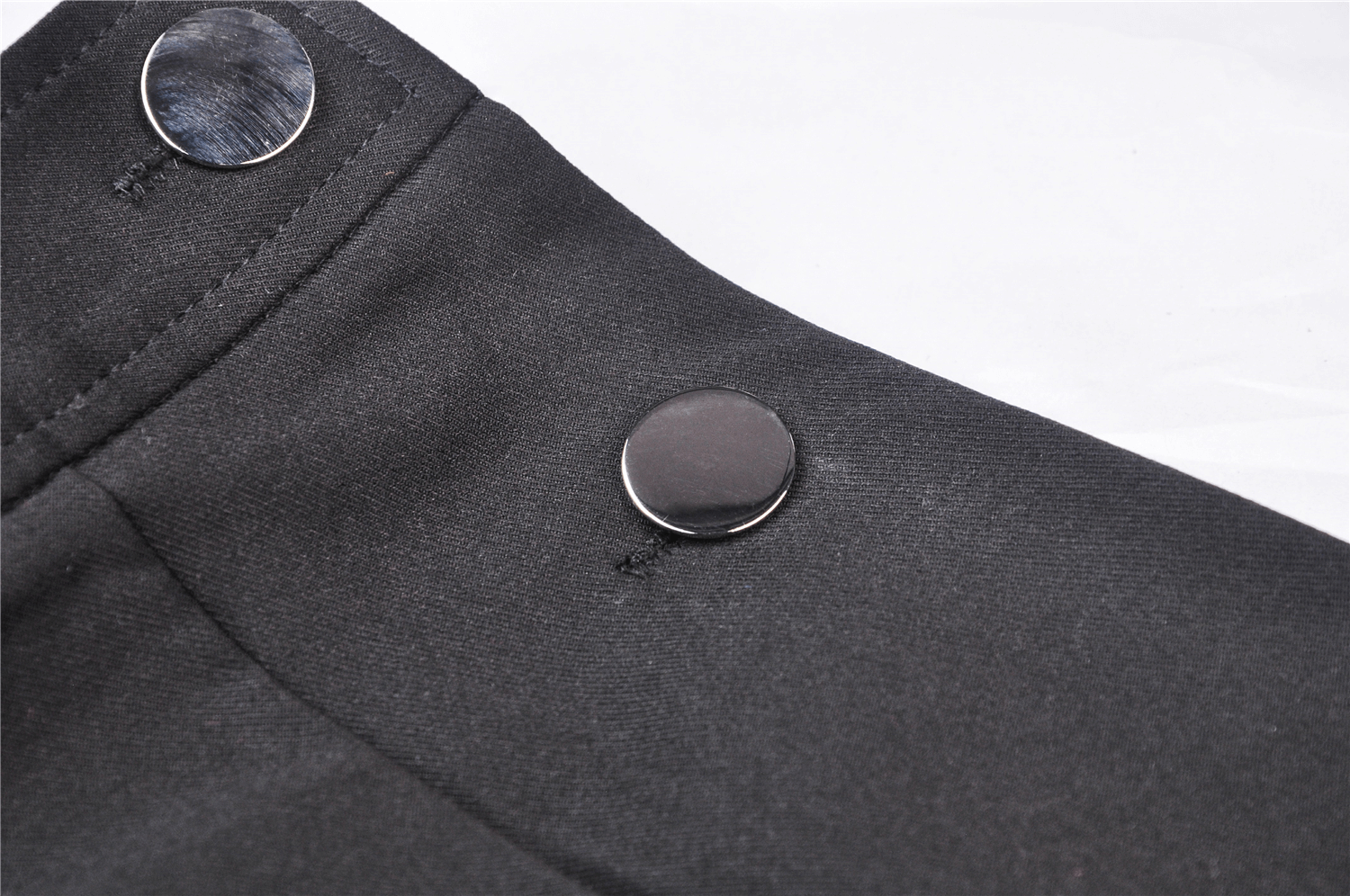 Close-up of stylish black buttons on a punk pentagram suspender dress, showcasing edgy design details.