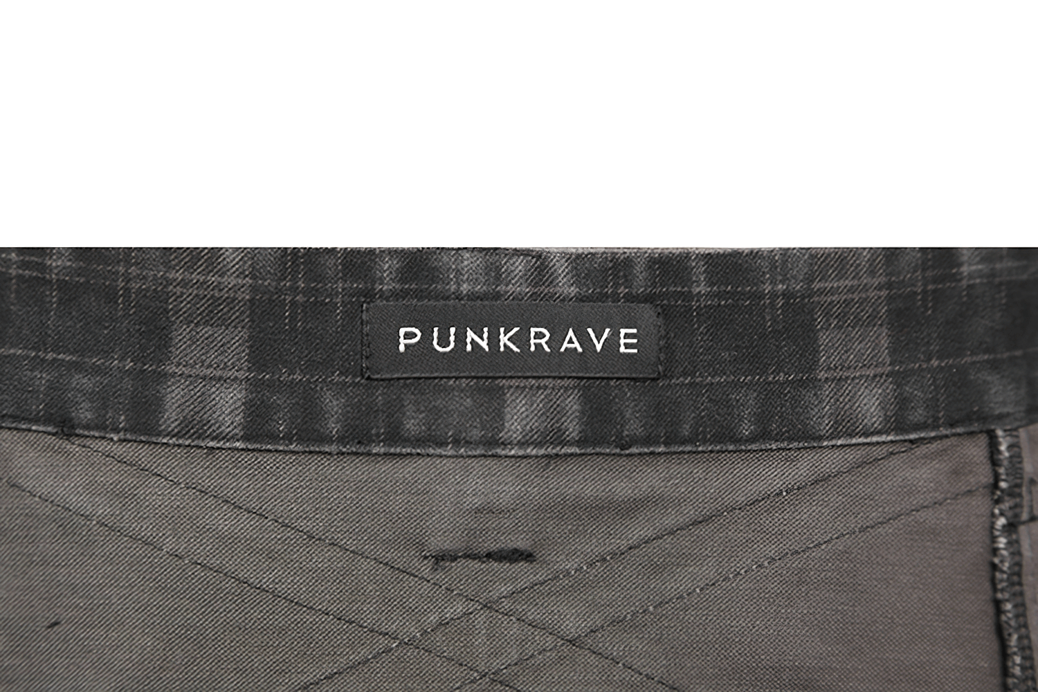 Close-up of the Punk Rave label on a black plaid kilt, showcasing its unique punk rock style.