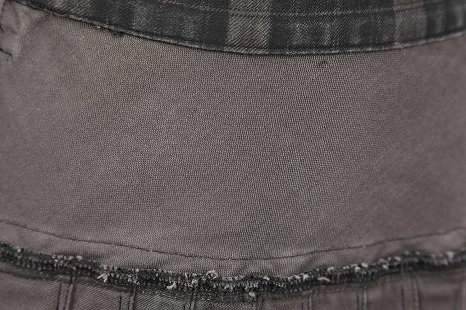 Close-up of the fabric texture on a men's punk plaid kilt, showcasing the black plaid and zipper detail.
