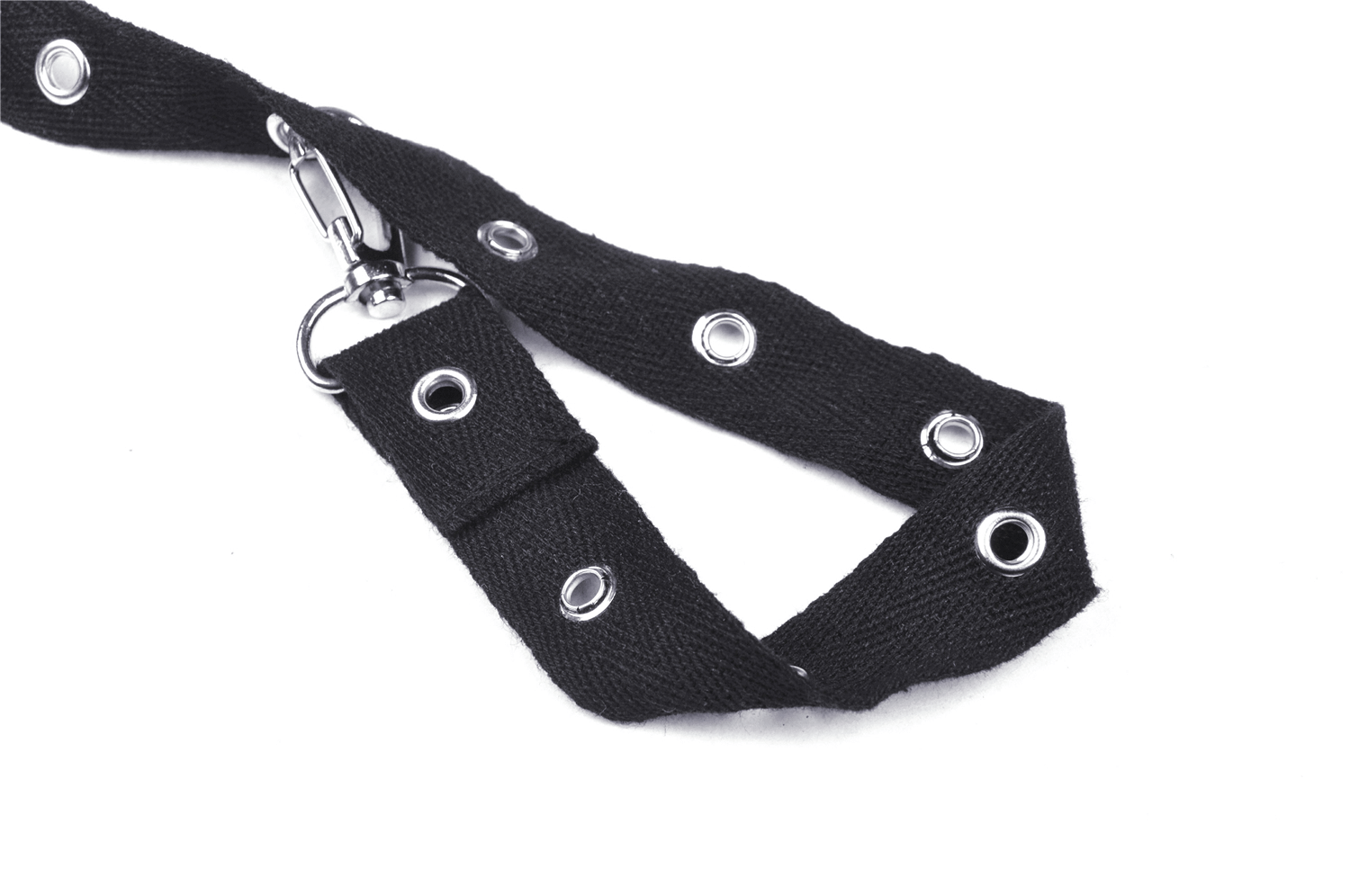 Close-up of a black fabric belt with metal grommets and a clip, perfect for punk fashion accessories.