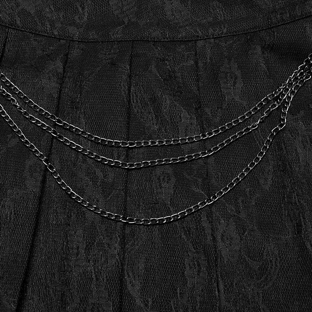 Close-up of punk pleated skirt with detachable chains and floral net design, showcasing intricate texture.