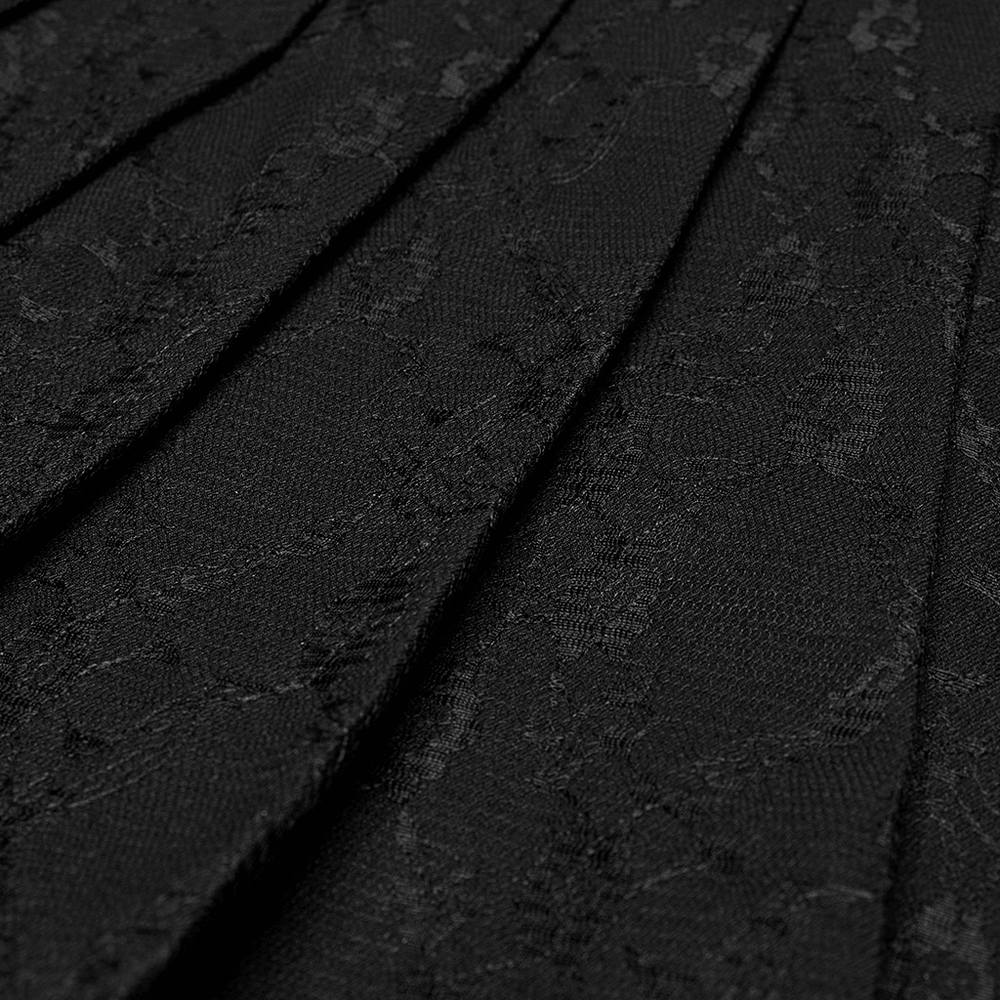 Close-up of black pleated skirt showcasing intricate floral net design and edgy punk style.