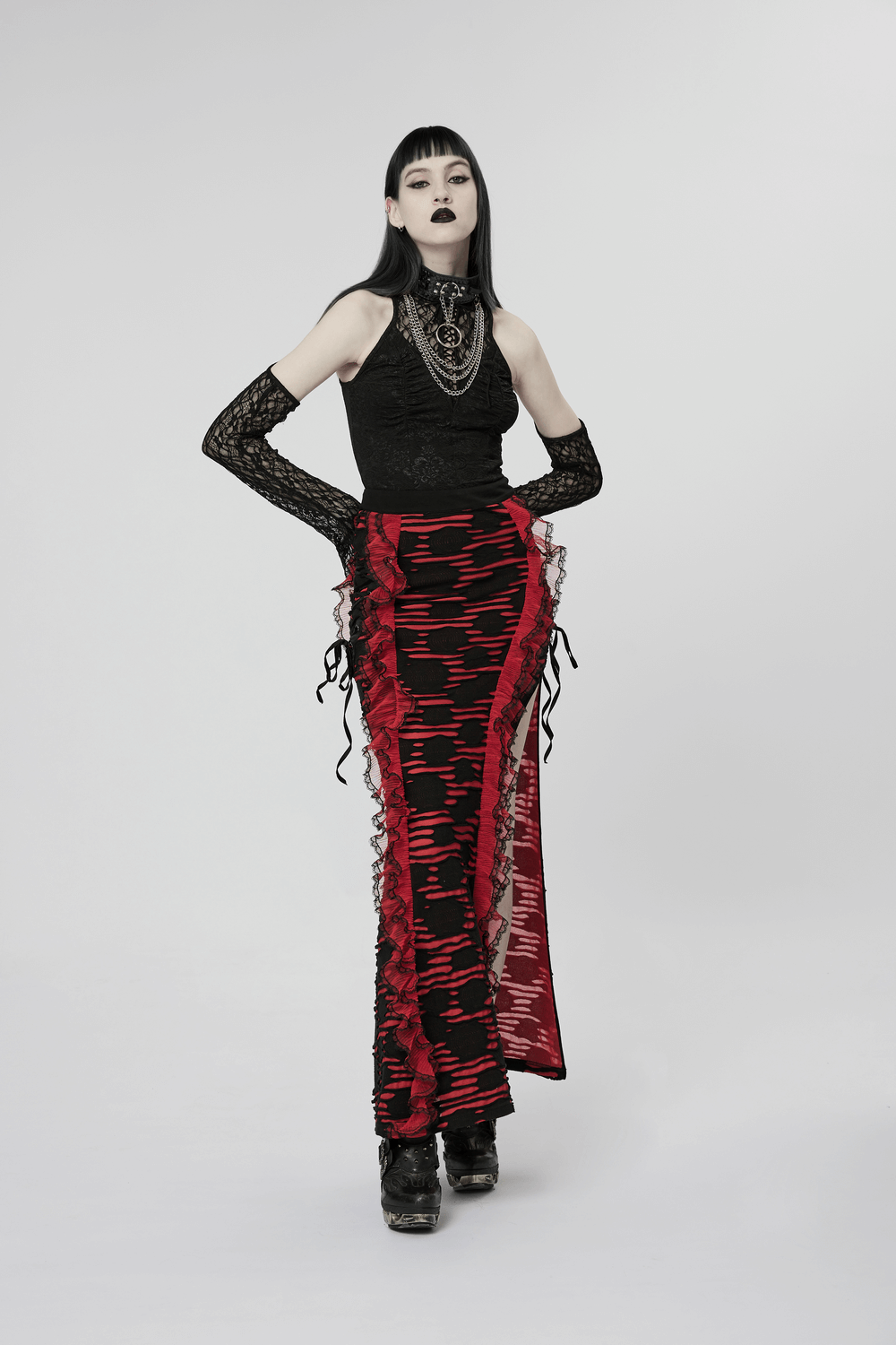 Model wearing a punk-inspired red and black dress with lace sleeves, showcasing a bold, rebellious fashion statement.